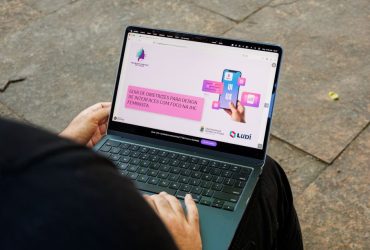 Pessoa utiliza notebook que exibe o Guia de Diretrizes para Design de Interfaces com Foco em IHC Feminista.