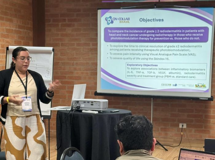 Pesquisadora Andreza Soares apresenta estudo sobre radiodermatite em pacientes com câncer de cabeça e pescoço durante evento científico.